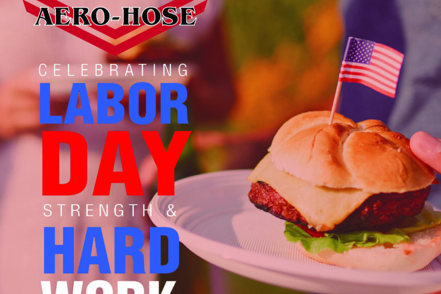 promotional image for auto-hose celebrating labor day, featuring a hand holding a hamburger with a small american flag, with blurry people in the background.