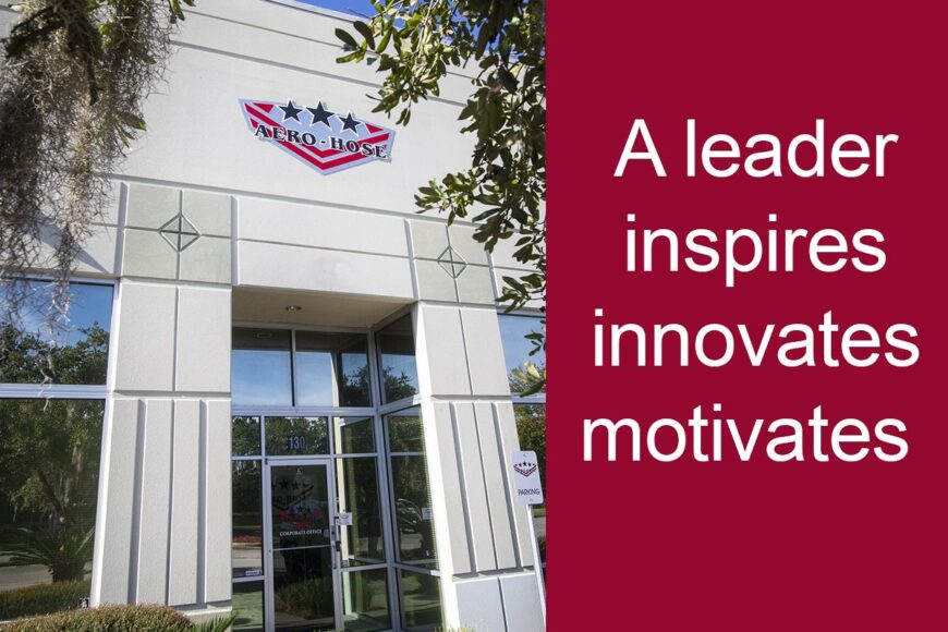 the building's exterior showcases a sign adorned with stars and an eagle. to the right, a red panel reads, "a leader inspires, innovates, motivates." trees and shrubs frame this scene of auto draft inspiration.