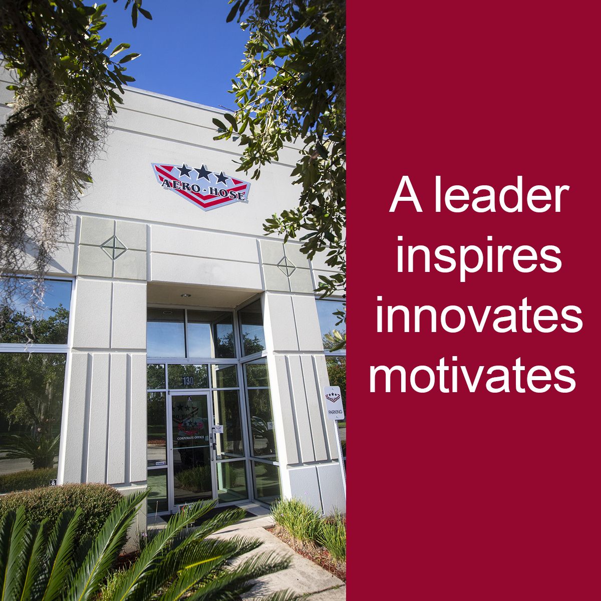 the building's exterior showcases a sign adorned with stars and an eagle. to the right, a red panel reads, "a leader inspires, innovates, motivates." trees and shrubs frame this scene of auto draft inspiration.